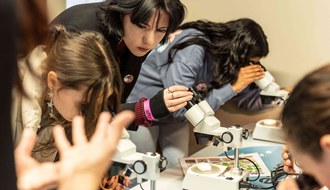 Ragazze che osservano formiche al microscopio
