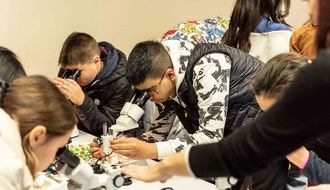 Ragazzi che osservano al microscopio